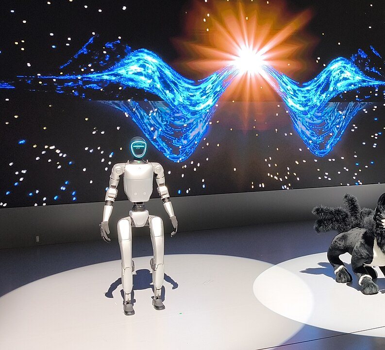 A compact humanoid robot on a stage with a light show behind it